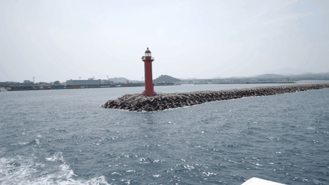 Red lighthouse on a breakwater in the sea