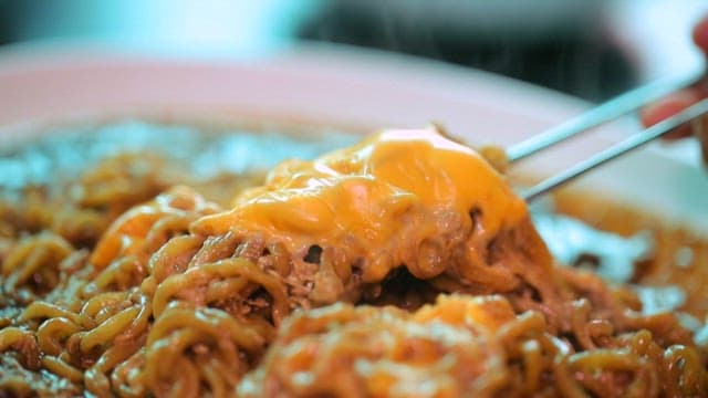 젓가락으로 들어올린 치즈 짜장라면