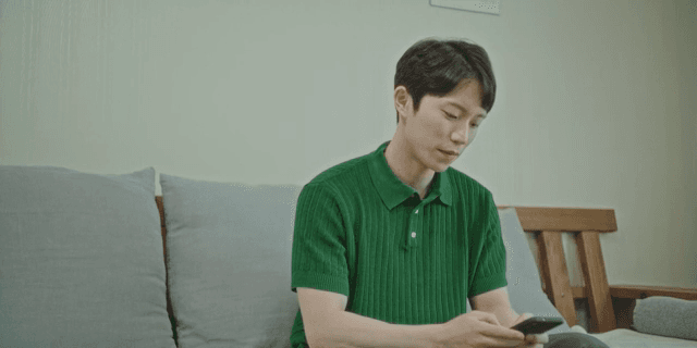 소파에서 스마트폰을 사용하는 남자