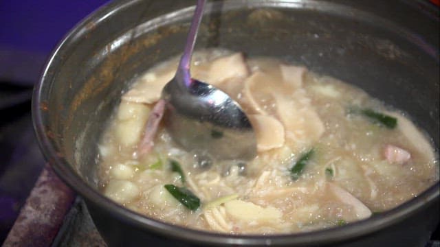 Adding beaten egg to noodle soup with chicken