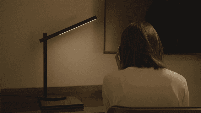 책상 앞에서 전화하는 여성의 뒷모습