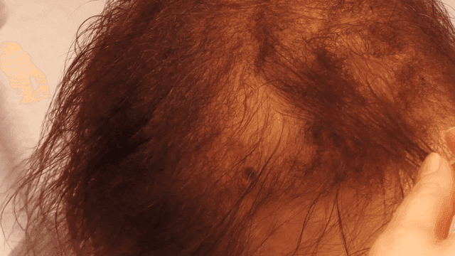 Hairdresser styling woman's hair with comb