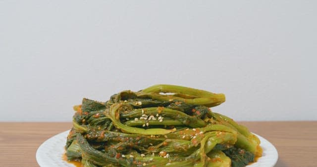 깨 뿌려진 갓김치를 젓가락으로 들어올리기