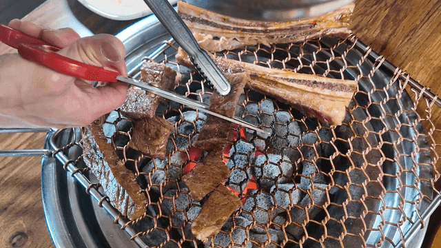 Scissors for cutting beef short ribs grilled over charcoal