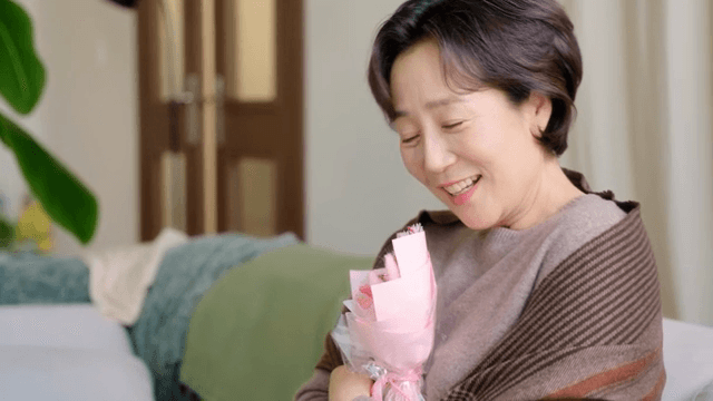 실내에서 꽃다발을 들고 미소 짓는 여성