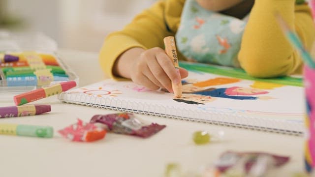 Child creatively coloring with crayons