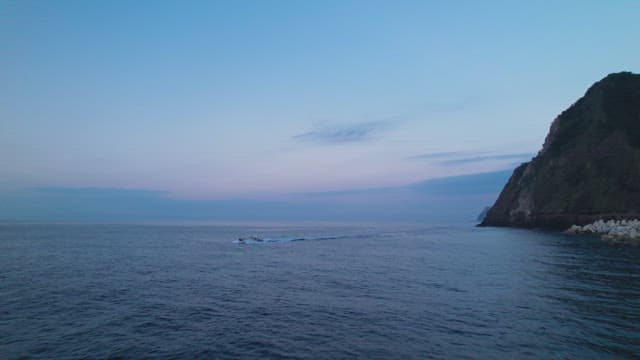 Boat sailing on the calm sea at dusk