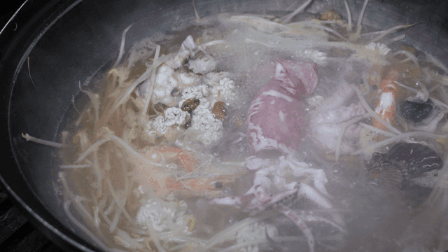 Seafood boiling in a pot with steam