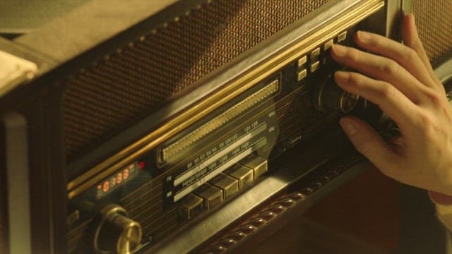 Hand tuning a vintage radio indoors