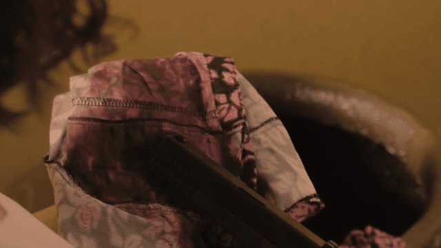 천에 싸인 총을 들고 있는 사람