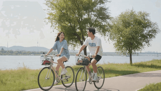 Couple cycling along a riverside path