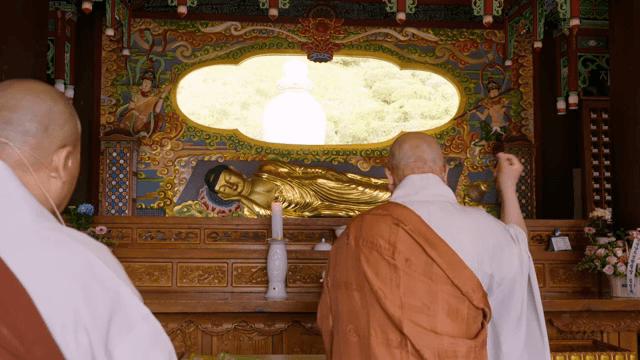 불상 앞에서 기도하는 승려들