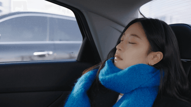 Side view of a woman sleeping soundly in a taxi
