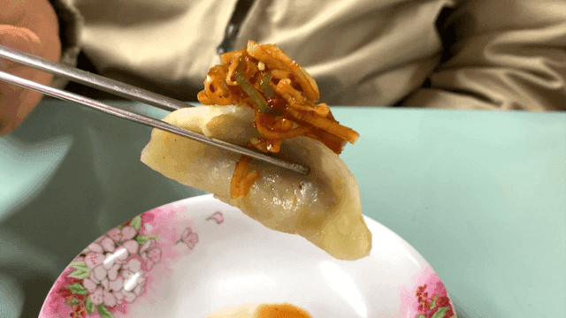 Dumplings with soy scallion sauce on a floral plate