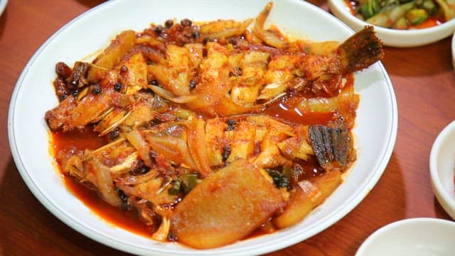 Spicy braised fish in a white bowl