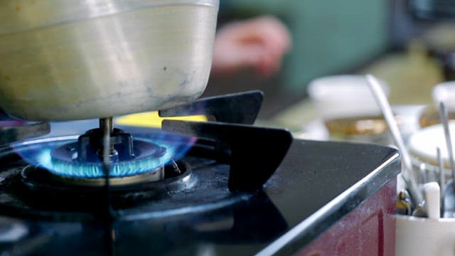 Person cleaning up next to a boiling kettle