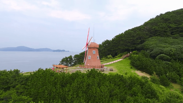 Windmill on a coastal hill with ocean view