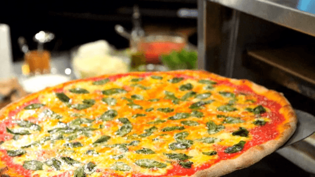 오븐에서 피자를 꺼내는 장면