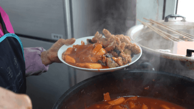 Plate of tteokbokki served with fried seaweed rolls