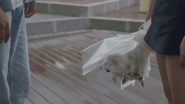 Woman giving strength to a man and holding a bouquet of flowers