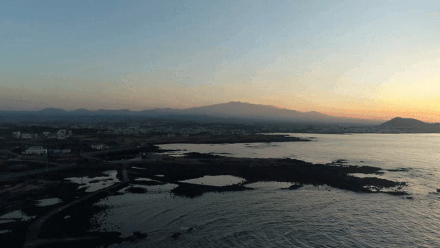 Sunset over the ocean with distant mountains
