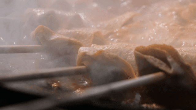 Fish cake skewers boiling in spicy broth