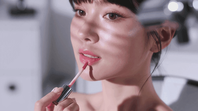 입술에 분홍색 틴트를 마르는 젊은 여성