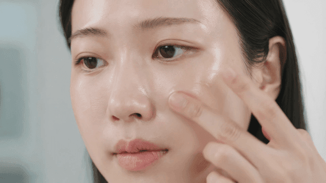 Woman applying skincare products to her face