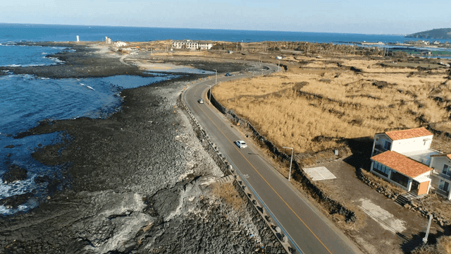 Coastal road with wide fields and ocean views