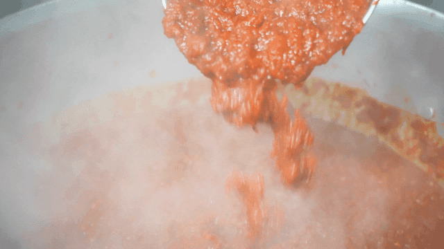 Tomato sauce poured into pot