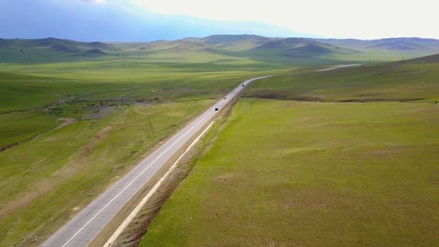 넓은 초원을 가로지르는 긴 도로