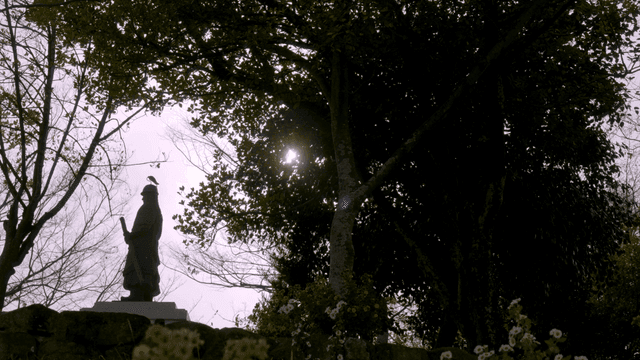 Statue in a serene forest with sunlight