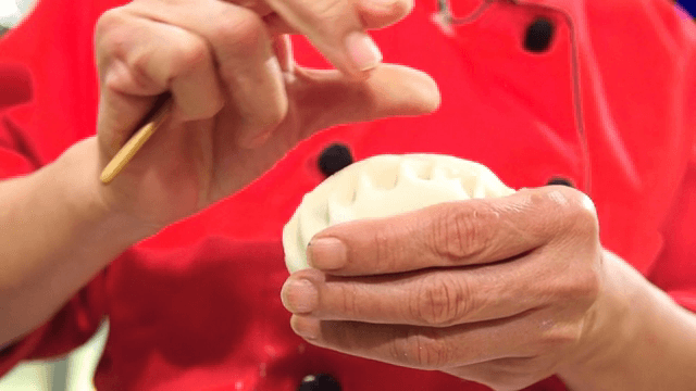 Hands crafting dumplings with precision