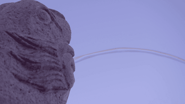 Traditional stone statue with water stream