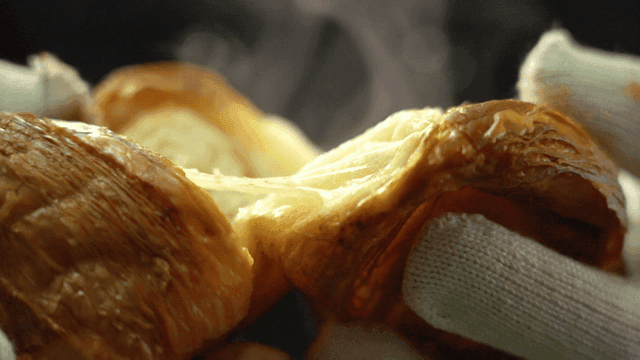 Hot croissant being torn apart