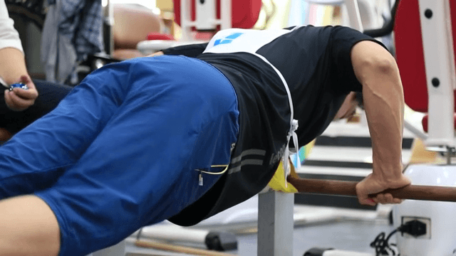 나무 막대를 잡고 팔굽혀펴기를 하는 선수