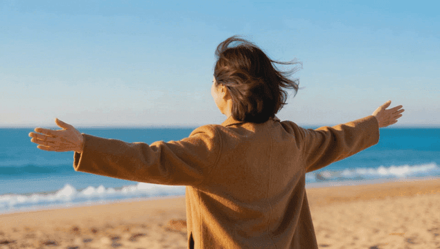 바다에서 두 팔을 벌리고 즐기는 여성