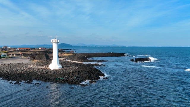 Lighthouse by the rocky seashore