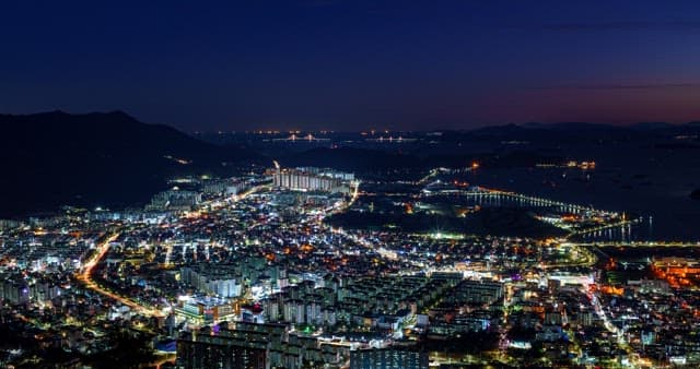 해안선과 맞닿은 도시의 낮부터 밤까지의 풍경