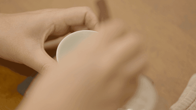 Hand holding teacup on table