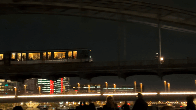 Night view of a city with a train crossing a bridge