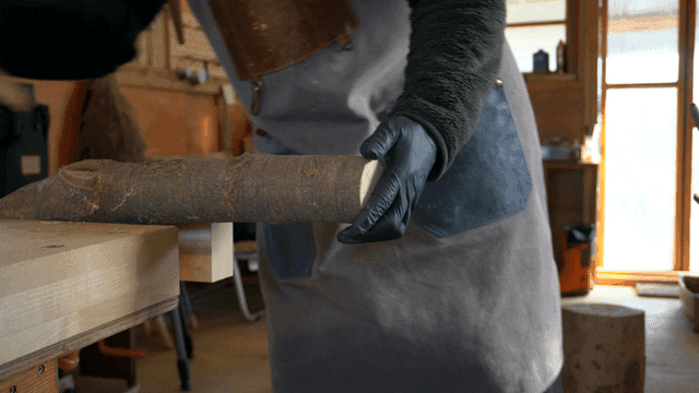 작업장에서 나무에 표시하고 톱질하는 목수