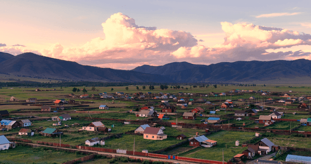 Sunset in a rural village with mountains in the background