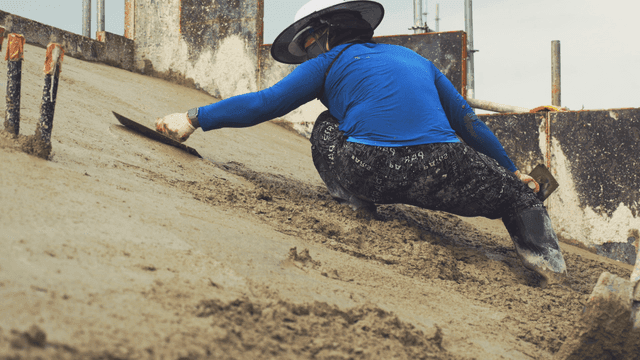 경사면에서 콘크리트를 다듬는 작업자