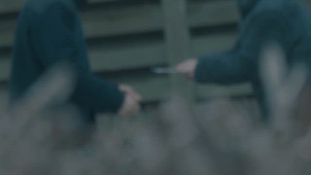 야외에서 물건을 교환하는 두 사람