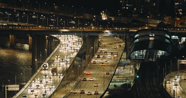 Illuminated City Traffic on Bridges and Roads at Night