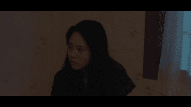 Woman sitting in dark room crying