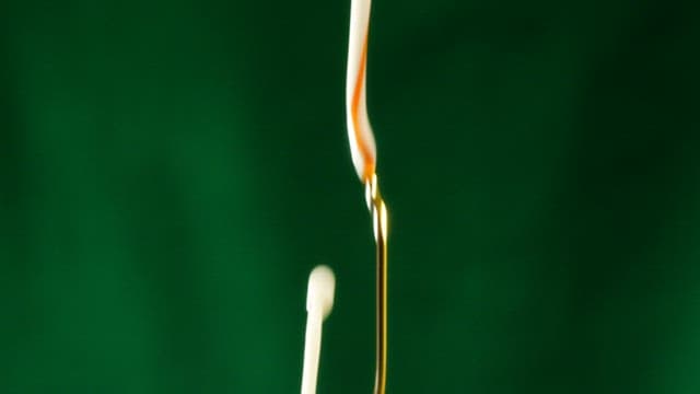 White milk and brown coffee poured against a green screen