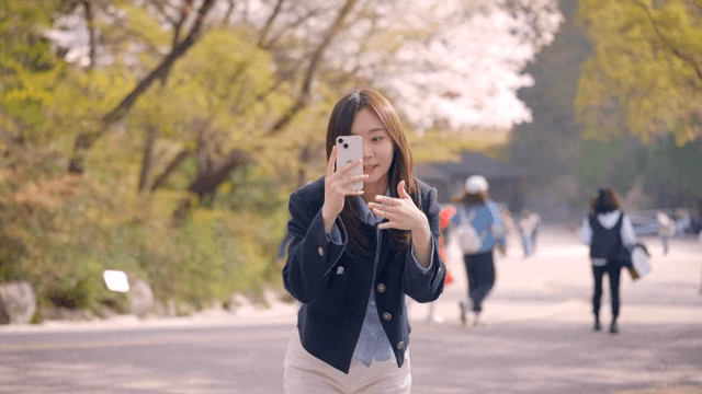 벚꽃이 핀 공원에서 사진을 찍어주는 여성