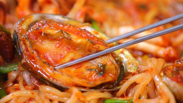 매운 해물찜의 전복을 집어드는 젓가락